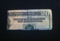 Picture of a twenty dollar bill folded in half and again lengthwise.