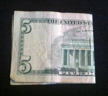 Picture of a five dollar bill folded in half.