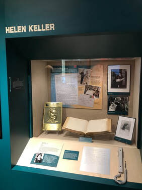 Helen Keller display that includes her personal bible, plaque, photos, and writings